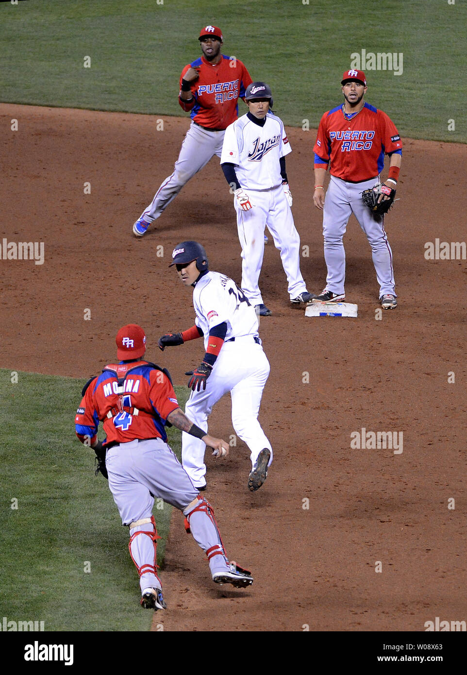 Puerto Rico's catcher Yadier Molina (4) chases down Japan's Seiichi  Uchikawa (24) after he was caught stealing in the eighth inning in the semi  finals of the World Baseball Classic at AT&T