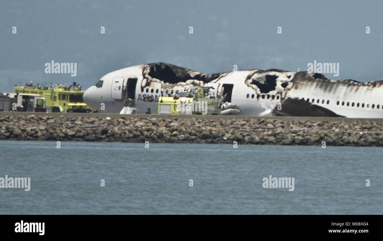 Emergency vehicles surround the remains of an Asiana Air Boeing 777 on the runway at San Francisco International Airport after it crashed on landing in San Francisco on July 6, 2013. The plane was arriving from Seoul.    UPI/Terry Schmitt Stock Photo