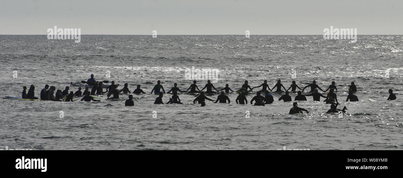 Surfers form a circle at the paddle out ceremony marking the start of ...