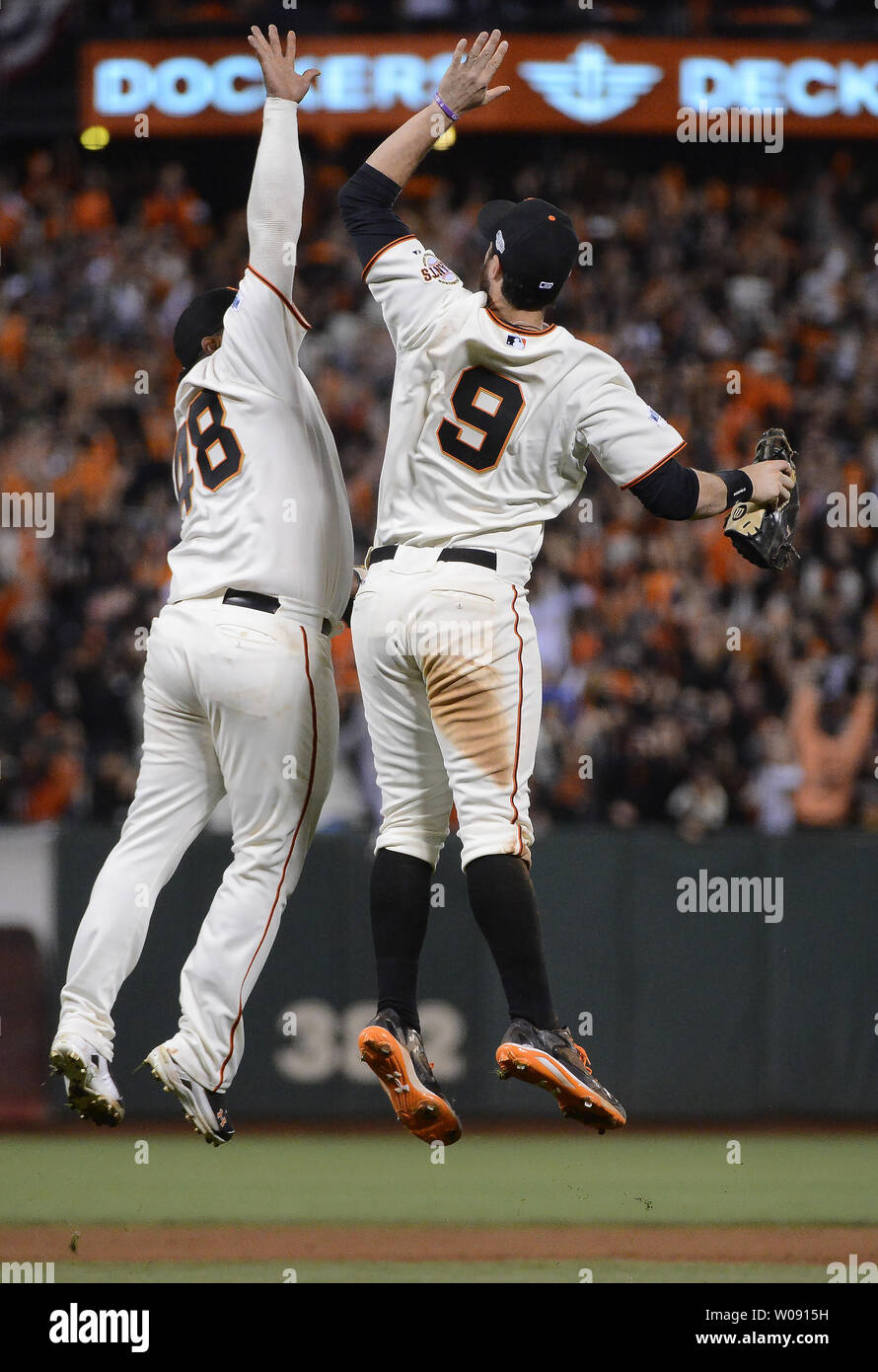 San Francisco Giants Pablo Sandoval (L) and Brandon Belt leap to