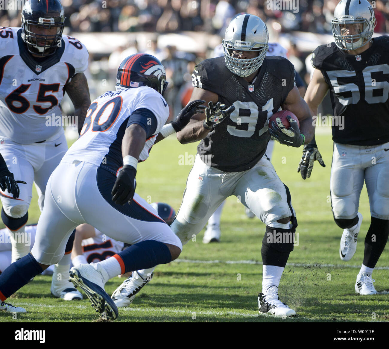 Oakland Raiders Justin Tuck (91) returns an intercepted pass by Denver Broncos Peyton Manning in the second quarter at O.co Coliseum in Oakland, California on November 9, 2014. The Broncos defeated the winless Raiders 41-17.     UPI/Terry Schmitt Stock Photo