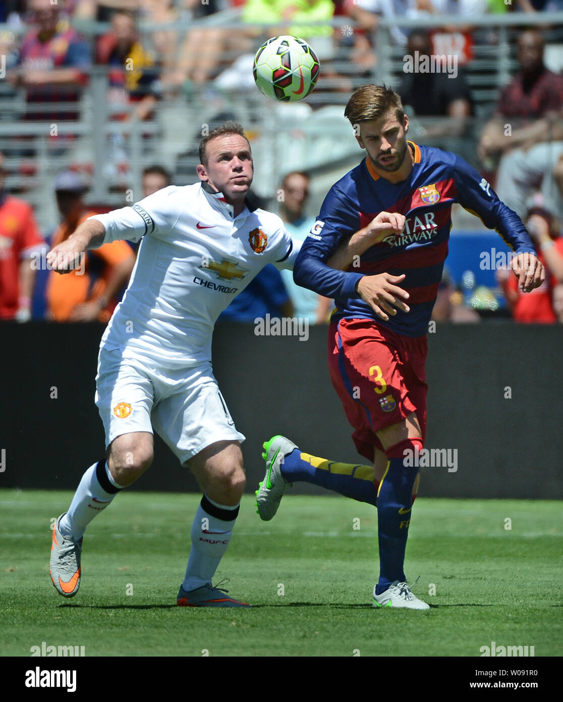 Manchester United's Wayne Rooney (L) fights for the ball with FC Barcelona's  Gerard Pique (3) in the first half in the 2015 International Champions Cup  North America at Levi's Stadium in Santa