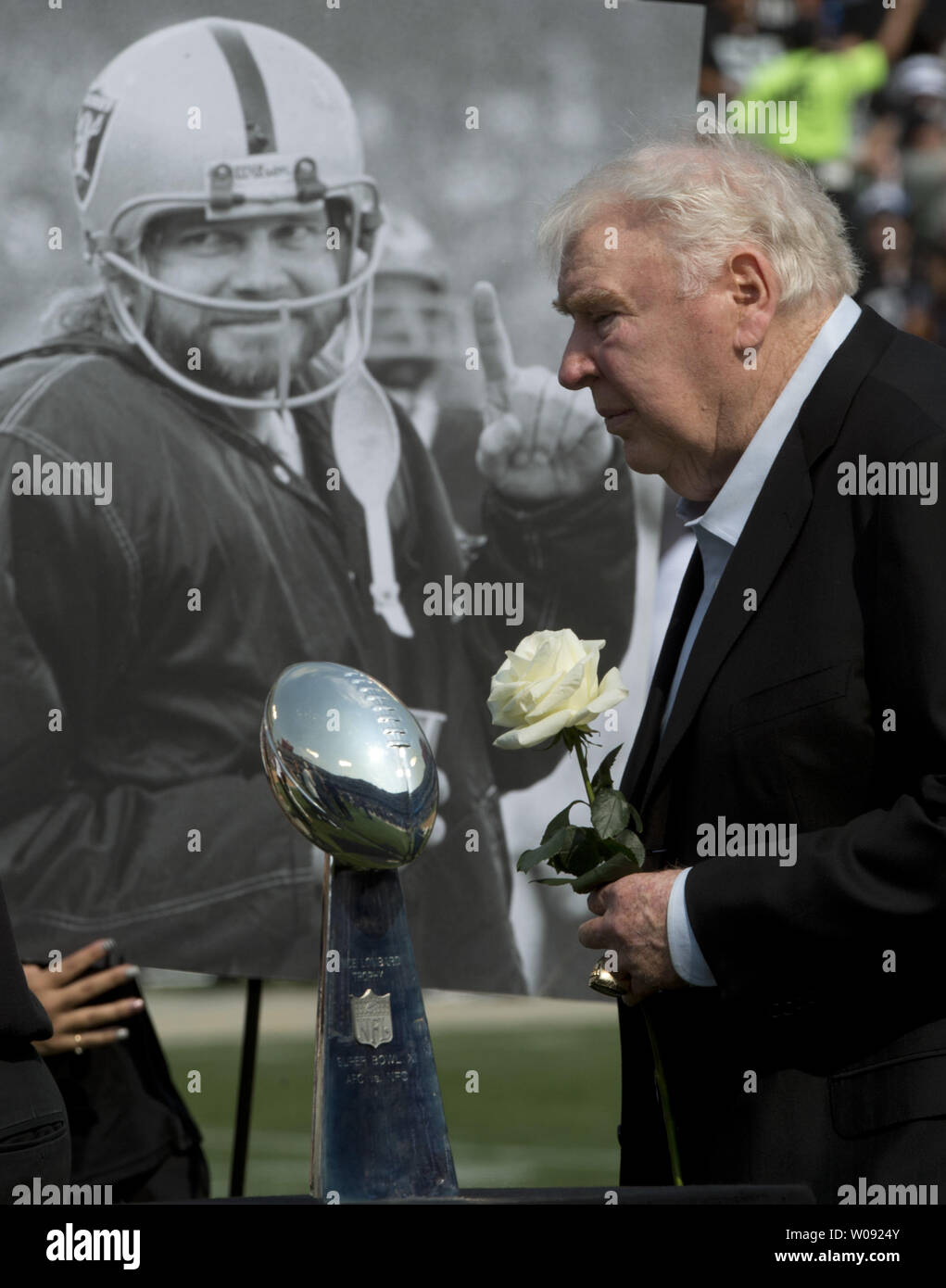 Former Oakland Raiders coach and sportscaster John Madden carries a white rose at a halftime tribute to the late Ken Stabler at O.co Coliseum in Oakland, California on September 13, 2015. Stabler, who helped Madden win Super Bowl XI  and the Vince Lombardi Trophy in the foreground, died in July, 2015. Photo by Terry Schmitt/UPI Stock Photo