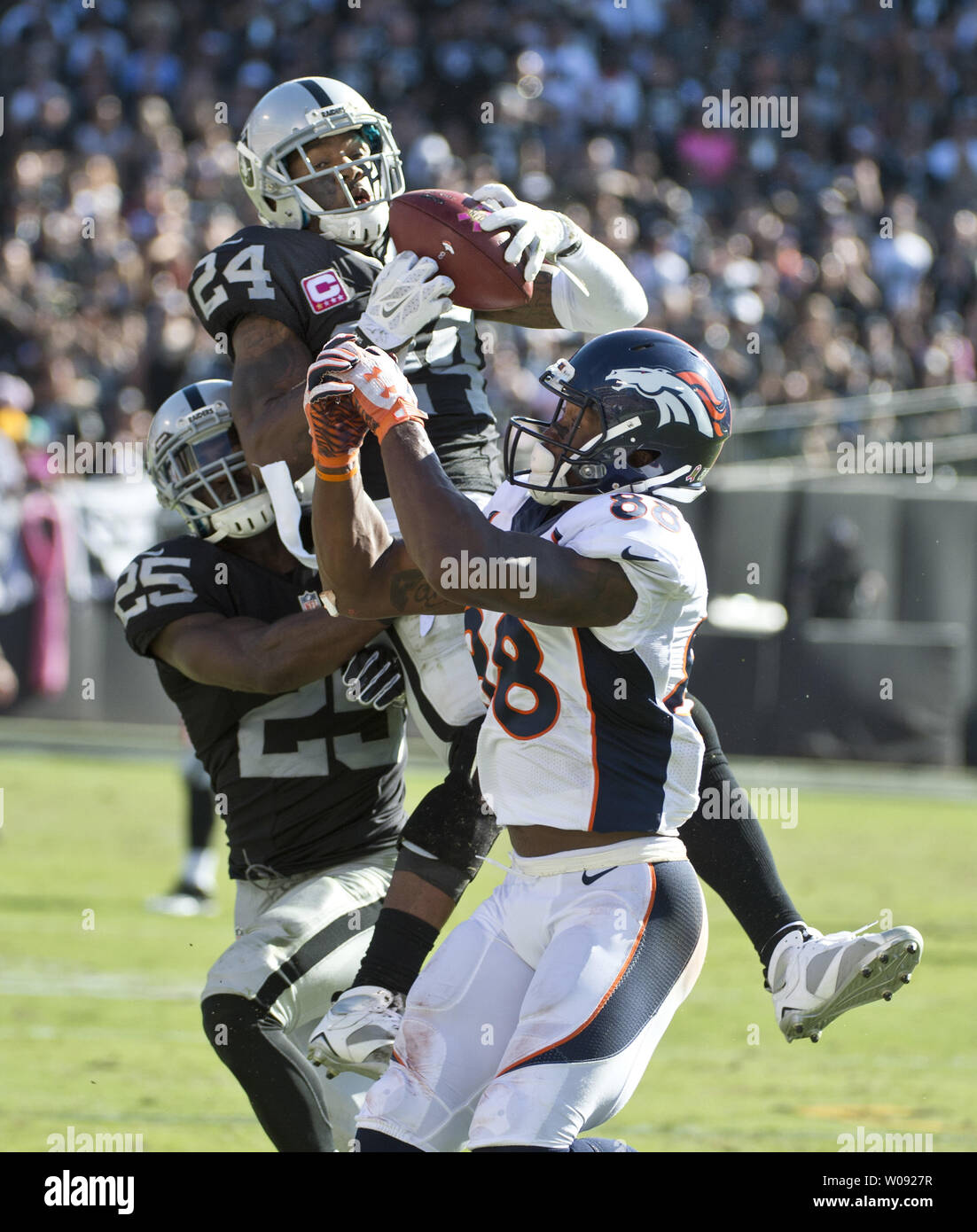 Oakland Raiders Charles Woodson (24) goes high to intercept a Denver Broncos Peyton Manning pass intended for Demaryius Thomas in the third quarter at O.co Coliseum in Oakland, California on October 11, 2015. The Broncos defeated the Raiders 16-10.  Photo by Terry Schmitt/UPI Stock Photo