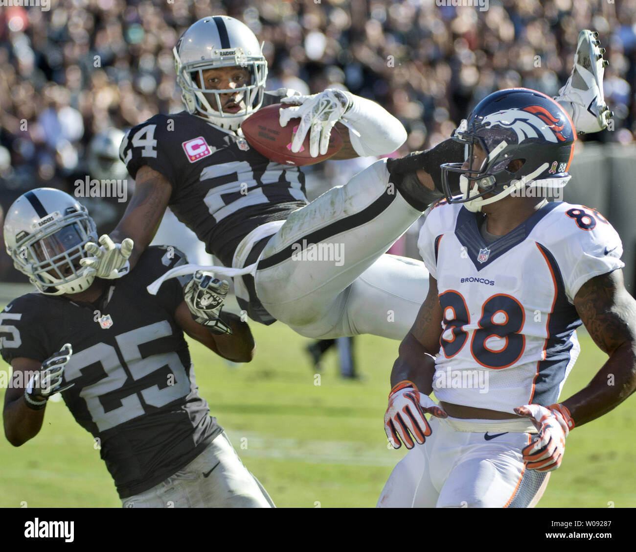 Oakland Raiders Charles Woodson (24) goes high to intercept a Denver Broncos Peyton Manning pass intended for Demaryius Thomas (88) in the third quarter at O.co Coliseum in Oakland, California on October 11, 2015. The Broncos defeated the Raiders 16-10.  Photo by Terry Schmitt/UPI Stock Photo