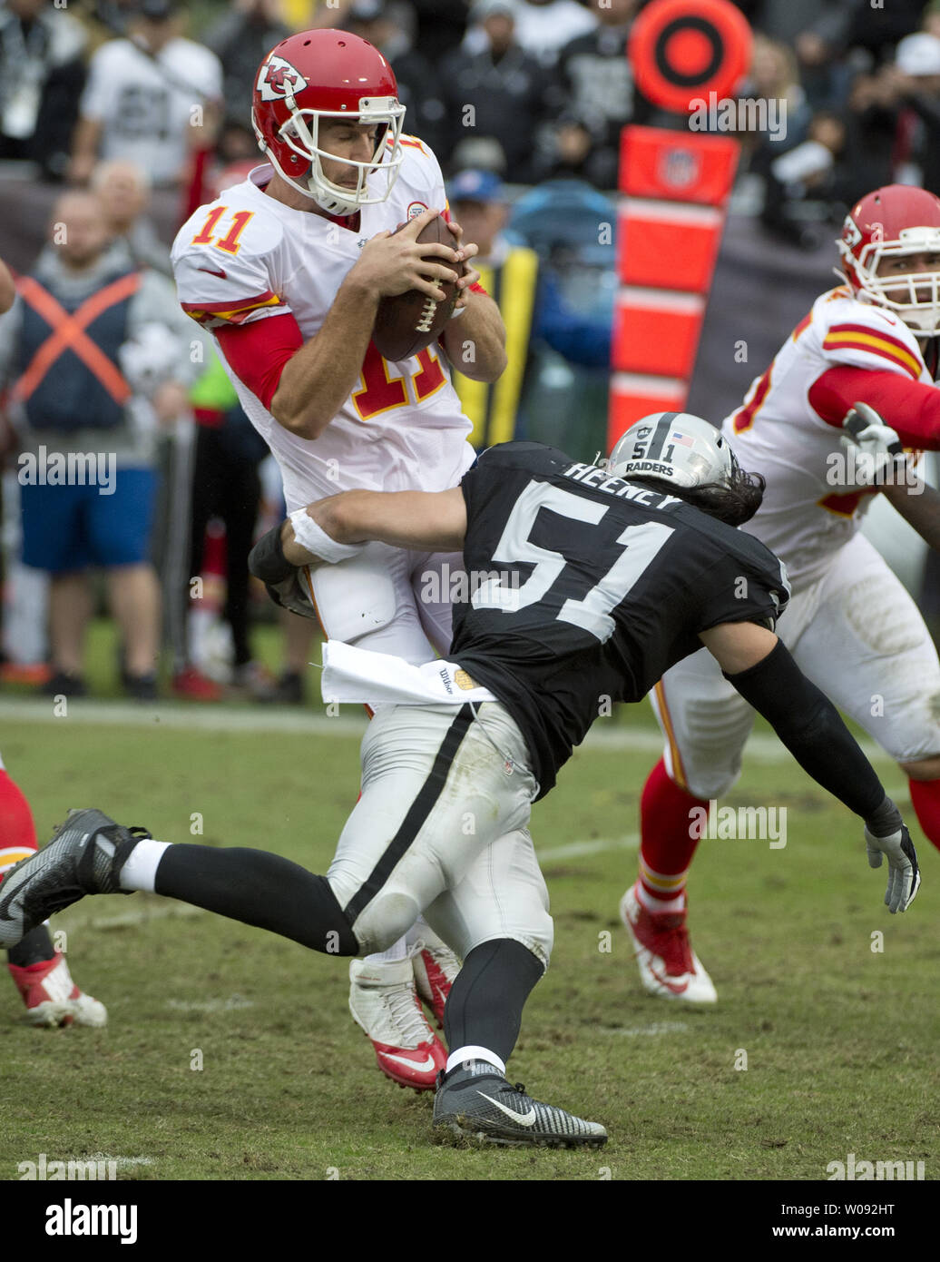 Kansas City Chiefs QB Alex Smith (11) is hit by Oakland Raiders Ben Heeney (51) in the second quarter at O.co Coliseum in Oakland, California on December 6, 2015. The Chiefs defeated the Raiders 34-20.    Photo by Terry Schmitt/UPI Stock Photo