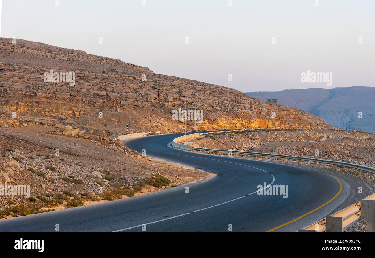 Winding road by the sea in Musandam Governorate of Oman surrounded by sandstones Stock Photo