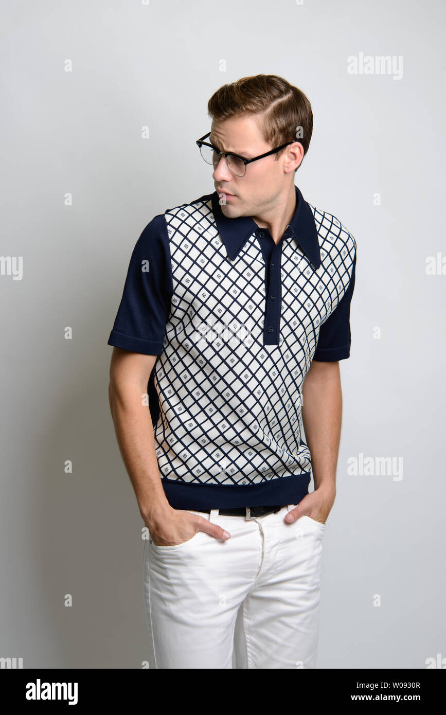 A Brown hair Caucasian male model wearing vintage eye glasses posing in vintage shirt, 60s bowling shirt, a preppy style fashion editorial. Stock Photo