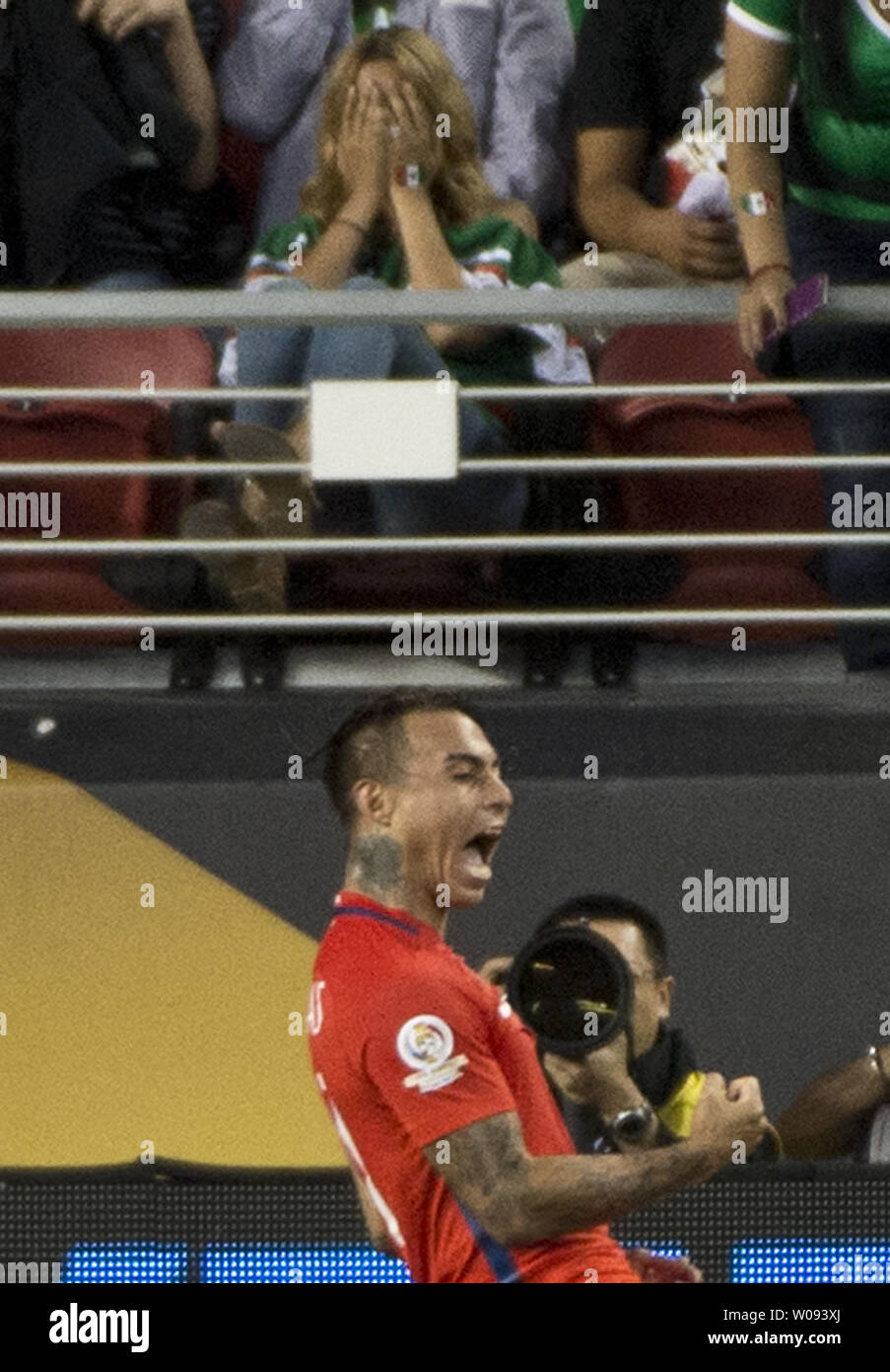 Chile's Eduardo Vargas celebrates a goal against Mexico in the second half as a Mexico fan covers her face at COPA America Centenario quarter-finals at Levi's Stadium in Santa Clara, California on June 18,  2016. Vargas had four goals as Chile annihilated Mexico 7-0.   Photo by Terry Schmitt/UPI Stock Photo