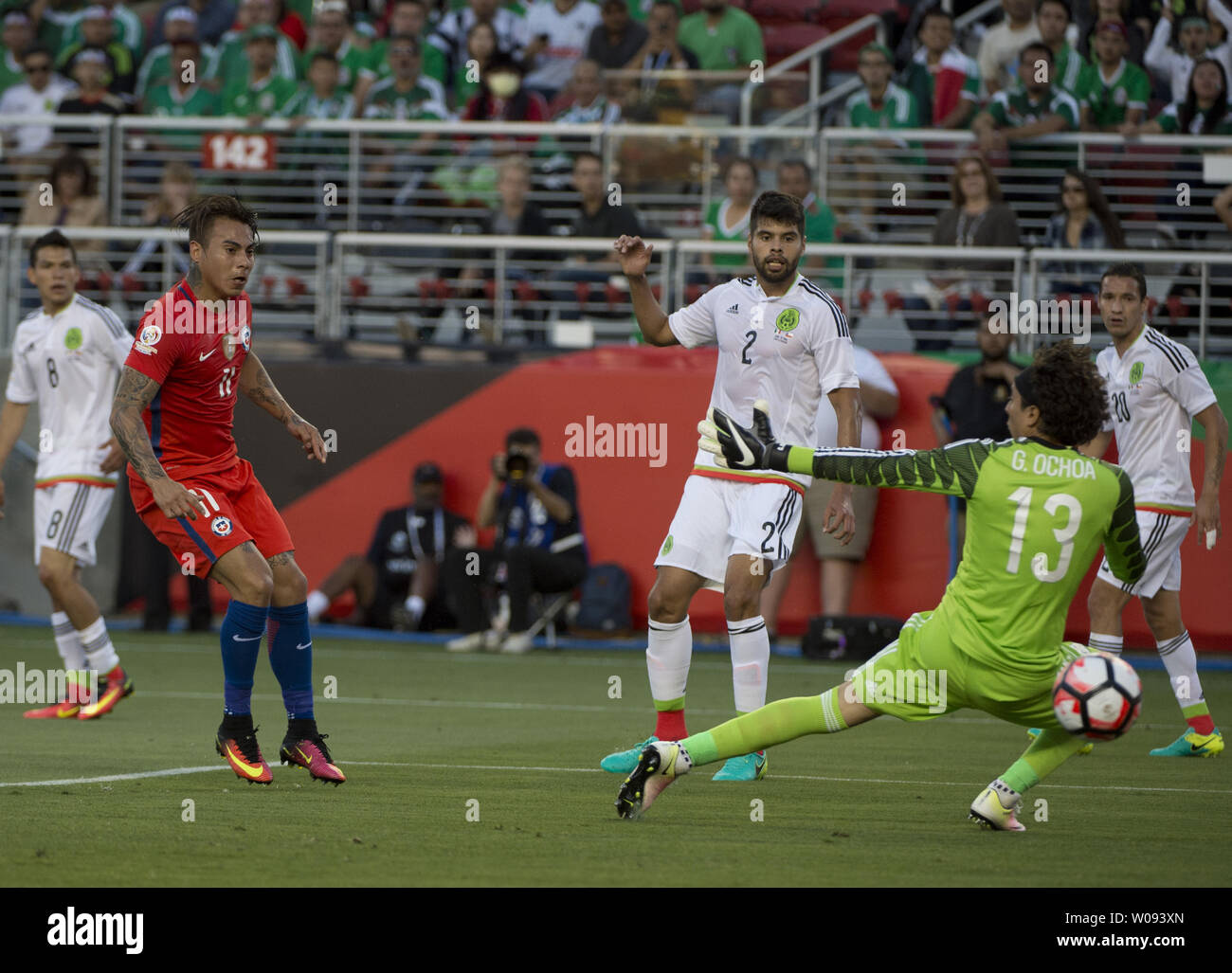Chile's Eduardo Vargas (L) puts the ball behind Mexico's goalie Guillermo Ochoa (13) for Chile's second goal in the first half at COPA America Centenario quarter-finals at Levi's Stadium in Santa Clara, California on June 18,  2016. Chile annihilated Mexico 7-0.   Photo by Terry Schmitt/UPI Stock Photo