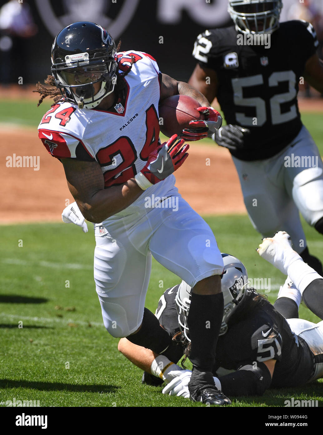 Atlanta Falcons RB Devonta Freeman (24) gets tripped up by Oakland Raiders Ben Heeney (50) in the first half at the Coliseum in Oakland, California on September 18, 2016. The Falcons defeated the Raiders 35-28.   Photo by Terry Schmitt/UPI Stock Photo