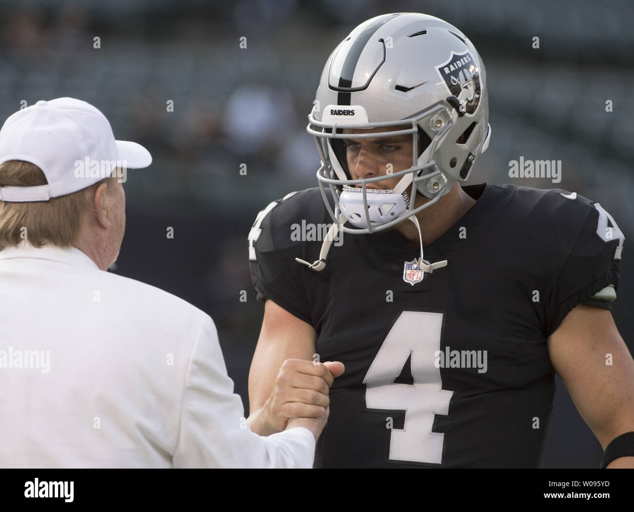 Oakland Raiders owner Mark Davis greets quarterback Derek Carr as the Raiders warm up to play the Detroit Lions at the Coliseum in Oakland, California on August 10, 2018. The Raiders defeated the Lions 16-10.     Photo by Terry Schmitt/UPI Stock Photo