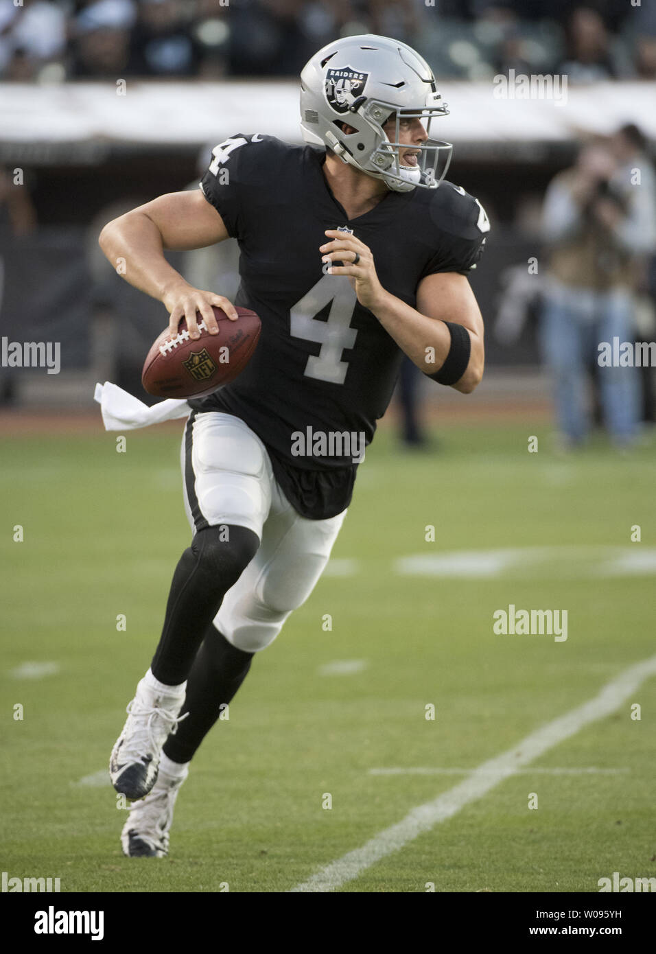 Oakland Raiders QB Derek Carr rolls out to pass in the first quarter against the Detroit Lions at the Coliseum in Oakland, California on August 10, 2018. The Raiders defeated the Lions 16-10.     Photo by Terry Schmitt/UPI Stock Photo