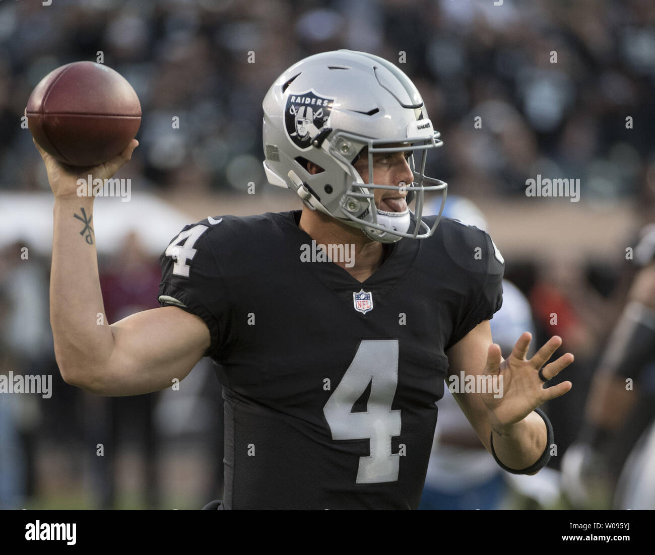 Oakland Raiders QB Derek Carr uses his toung and his arm to pass in the first quarter against the Detroit Lions at the Coliseum in Oakland, California on August 10, 2018. The Raiders defeated the Lions 16-10.     Photo by Terry Schmitt/UPI Stock Photo