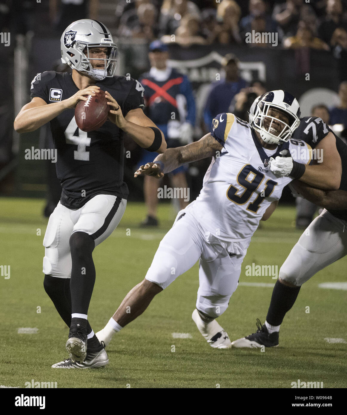 Oakland Raiders QB Derek Carr (4) rolls out to pass against the Los Angeles Rams in the first quarter at the Coliseum in Oakland, California on Monday, September 10, 2018. Carr threw three interceptions as the Rams defeated the Raiders 33-13.       Photo by Terry Schmitt/UPI Stock Photo