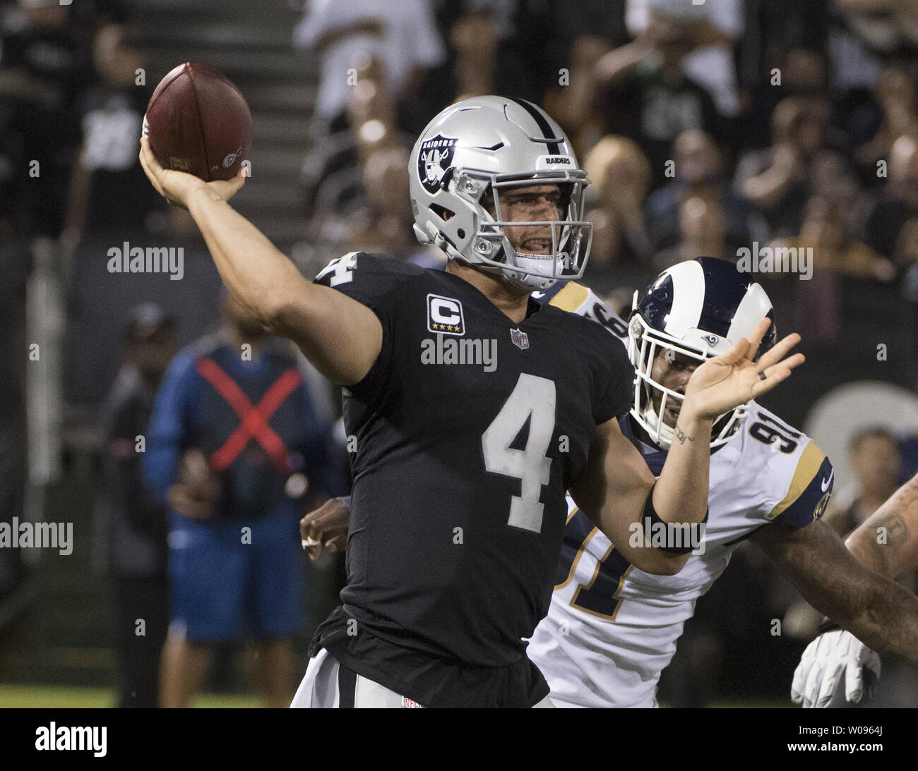 Oakland Raiders QB Derek Carr (4) rolls out to pass against the Los Angeles Rams in the first quarter at the Coliseum in Oakland, California on Monday, September 10, 2018. Carr threw three interceptions as the Rams defeated the Raiders 33-13.       Photo by Terry Schmitt/UPI Stock Photo