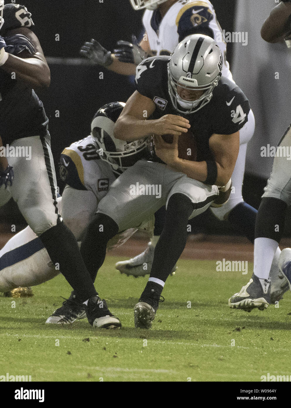 Oakland Raiders QB Derek Carr (4) is sacked by Los Angeles Rams Michael Brockers for a loss of three yards in the third quarter at the Coliseum in Oakland, California on Monday, September 10, 2018. The Rams defeated the Raiders 33-13.       Photo by Terry Schmitt/UPI Stock Photo