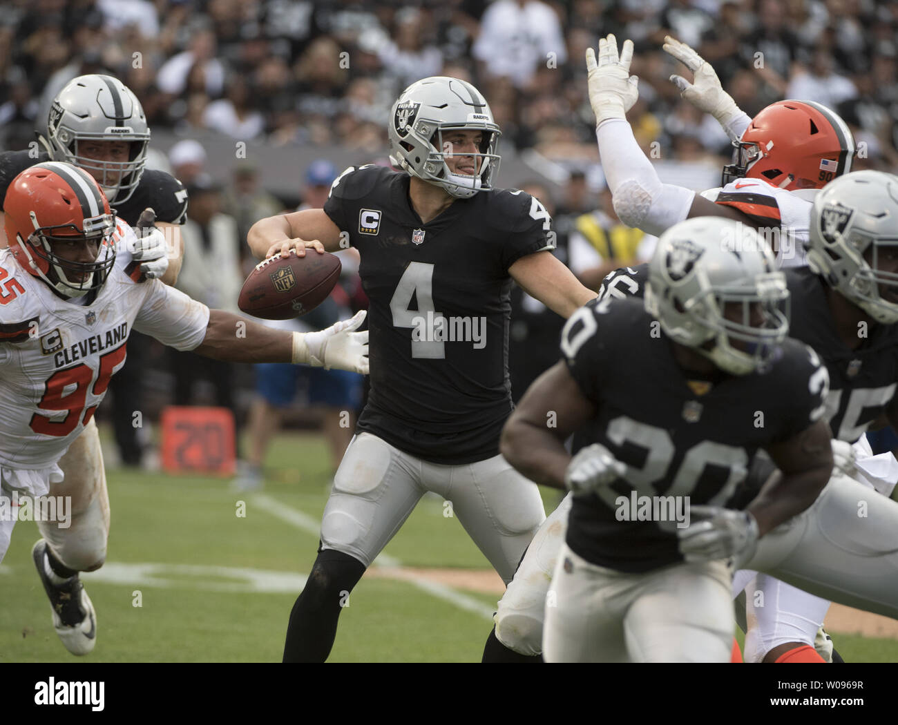 Oakland Raiders QB Derek Carr (4) throws under pressure  from the Cleveland Browns at the Coliseum in Oakland, California on September 30, 2018. The Raiders defeated the Browns 45-42 in overtime.     Photo by Terry Schmitt/UPI Stock Photo