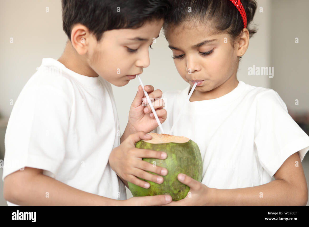 Two children sharing coconut drink Stock Photo Alamy