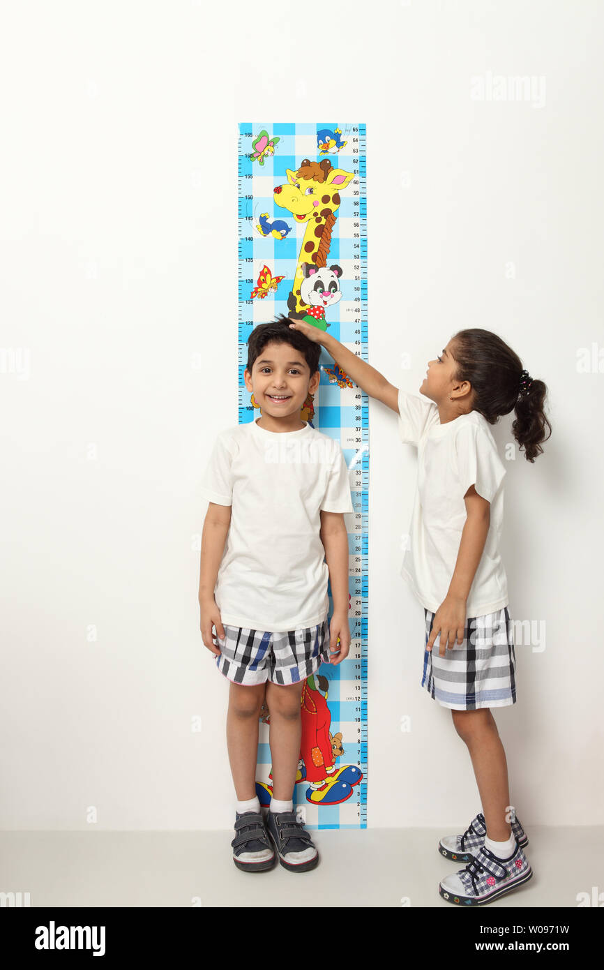 https://c8.alamy.com/comp/W0971W/girl-measuring-height-of-a-boy-W0971W.jpg