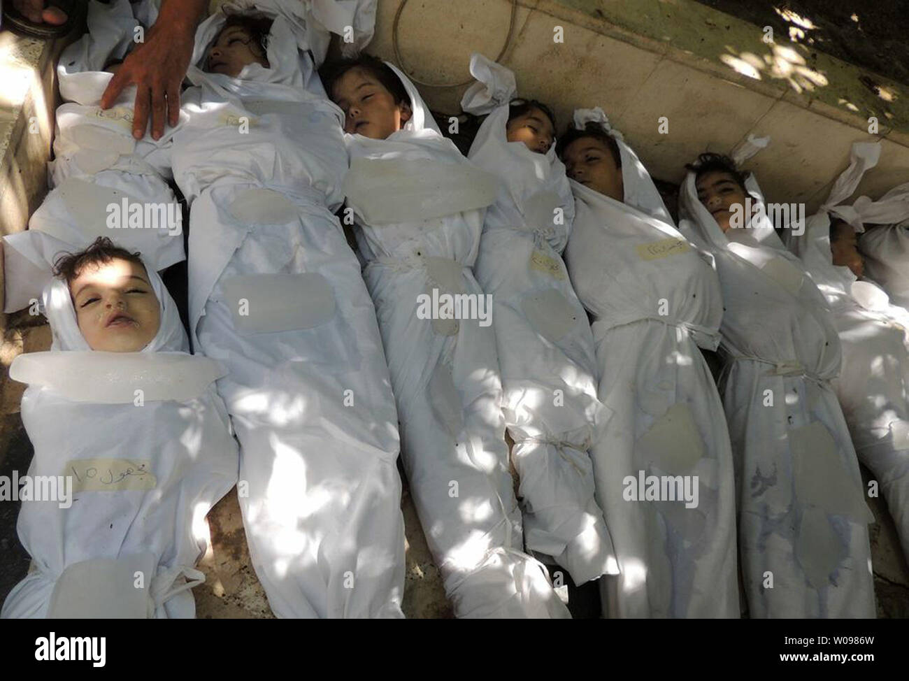 Dead children lie on the ground as Syrian rebels claim they were killed in a toxic gas attack by pro-government forces in eastern Ghouta, on the outskirts of Damascus in Syria on August 21, 2013. The Syrian government has denied the claims from the opposition that it has used chemical weapons. The UN is investigating. UPI/Diaa El Din Stock Photo