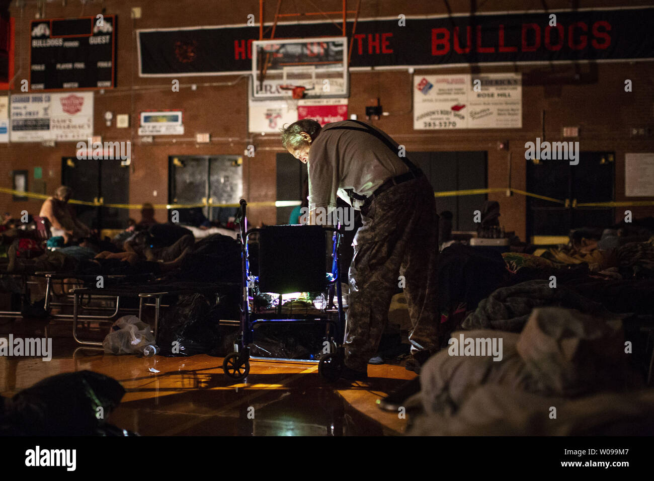 A man collects his belongings after spending the night at an evacuation