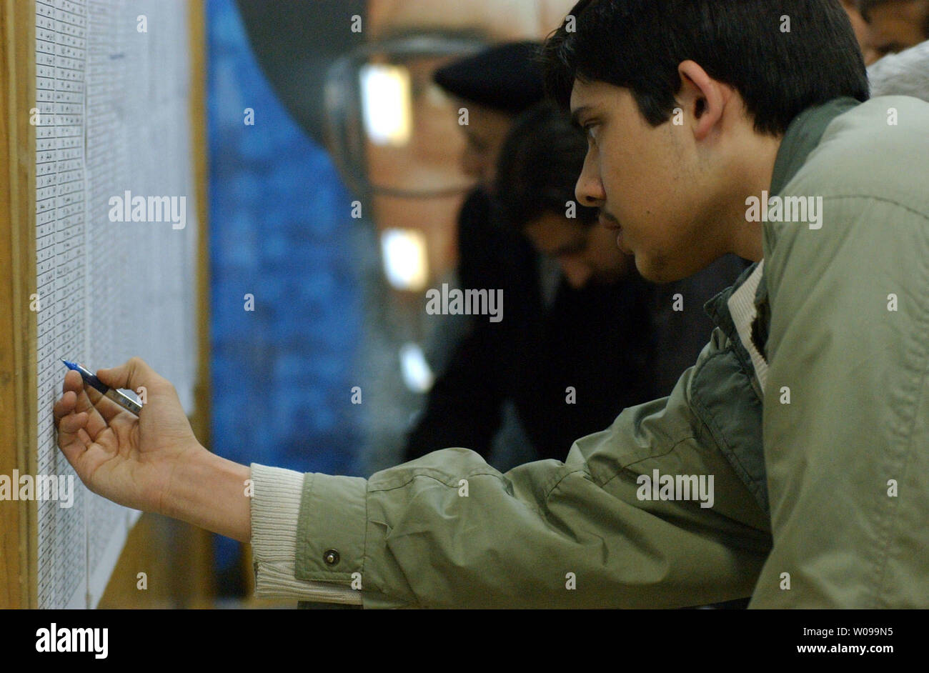 An Iranian checks his ballot before casting it in national parliamentary elections in Tehran, Iran Friday, Feb. 20, 2004. Hardline candidates are expected to sweep the vote, as Iran's pro-reform parties have urged a mass boycott after the conservative theocracy banned more than 2,400 candidates .   (UPI Photo/Ali Khaligh) Stock Photo