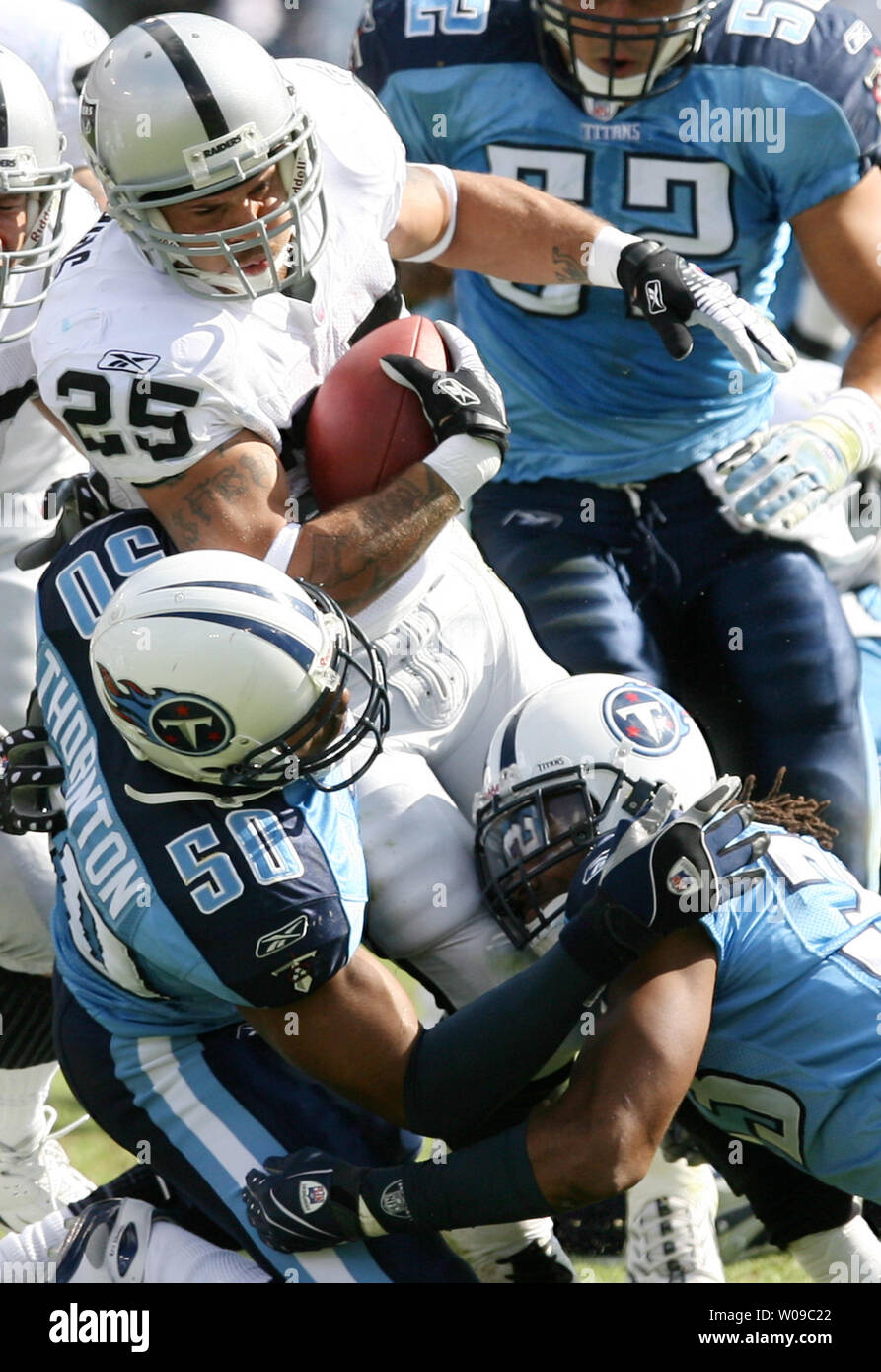 Tennessee Titans linebacker David Thornton (50) and Titans defensive back Michael Griffin (33) tackle Oakland Raiders runningback Justin Fargas (25) during a football game at LP Field in Nashville, Tennessee on October 28, 2007.  The Titans defeated the Raiders 13-9. (UPI Photo/Frederick Breedon IV) Stock Photo