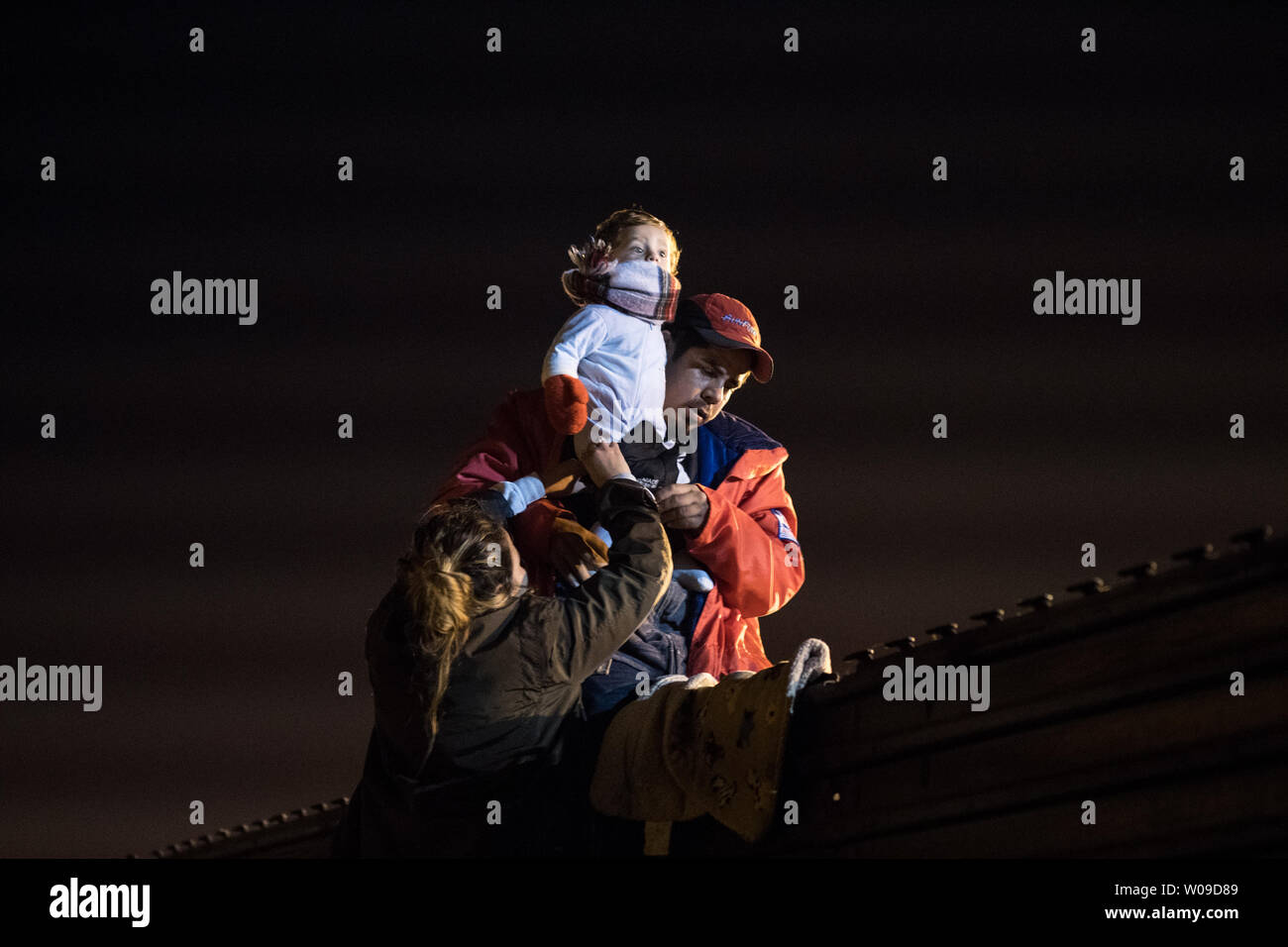 A family from Honduras traveling with the migrant caravan gets ready to climb the fence in Tijuana, Mexico on December 26, 2018.   Frustration has been growing in the last few weeks at the length of the asylum process so instead of continuing to wait some migrants are trying to climb the fence from Tijuana to seek asylum in the United States.   The U.S. government is in a partial shutdown due to a funding argument about the border.   Photo by Ariana Drehsler/UPI Stock Photo