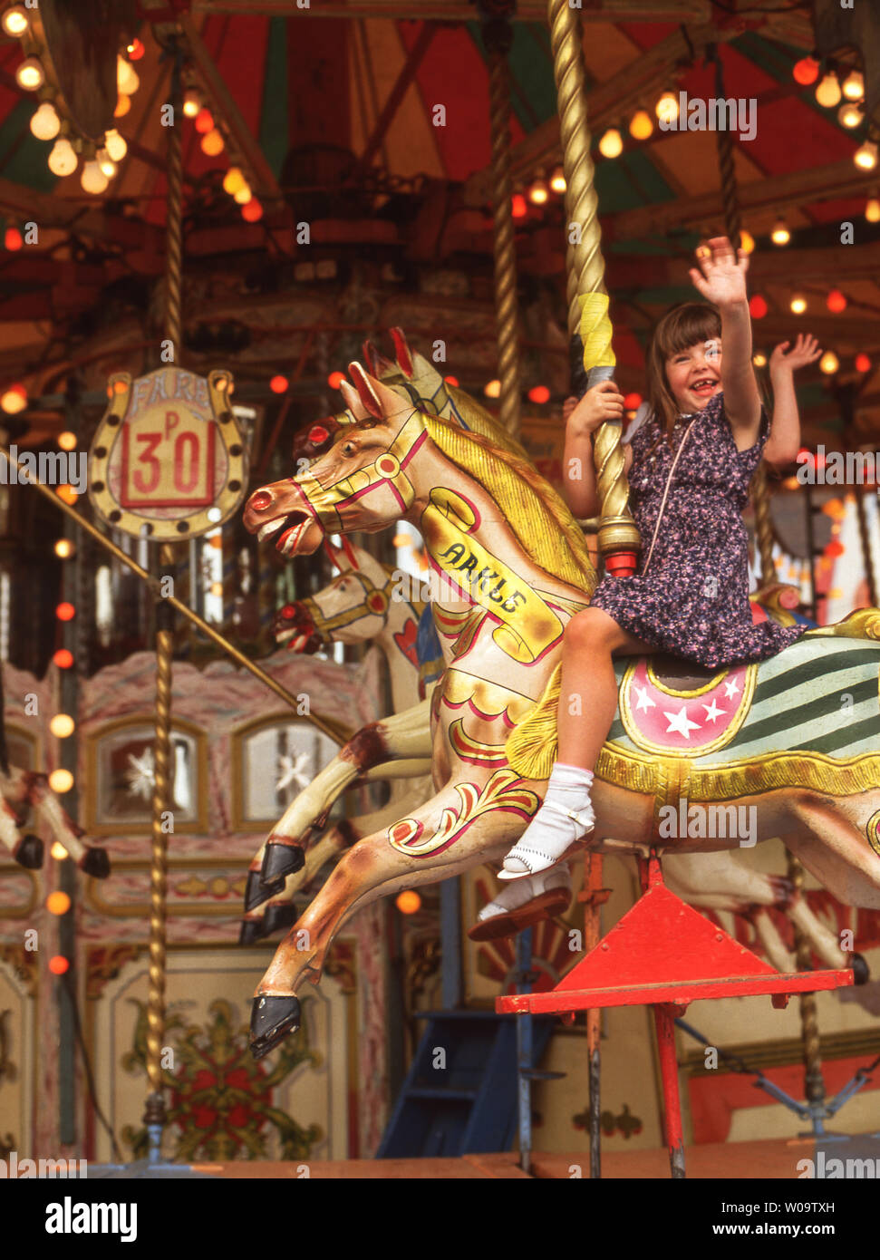 Two young children riding on the Big Horses Carrousel at the Hoppings Fair.Newcastle upon Tyne. England. Stock Photo