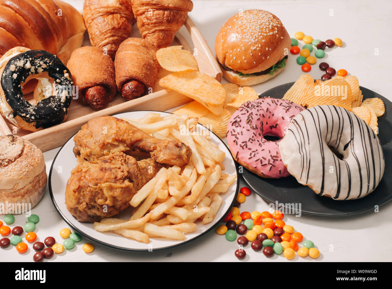 fast food and unhealthy eating concept - close up of fast food snacks and cola drink on white table Stock Photo