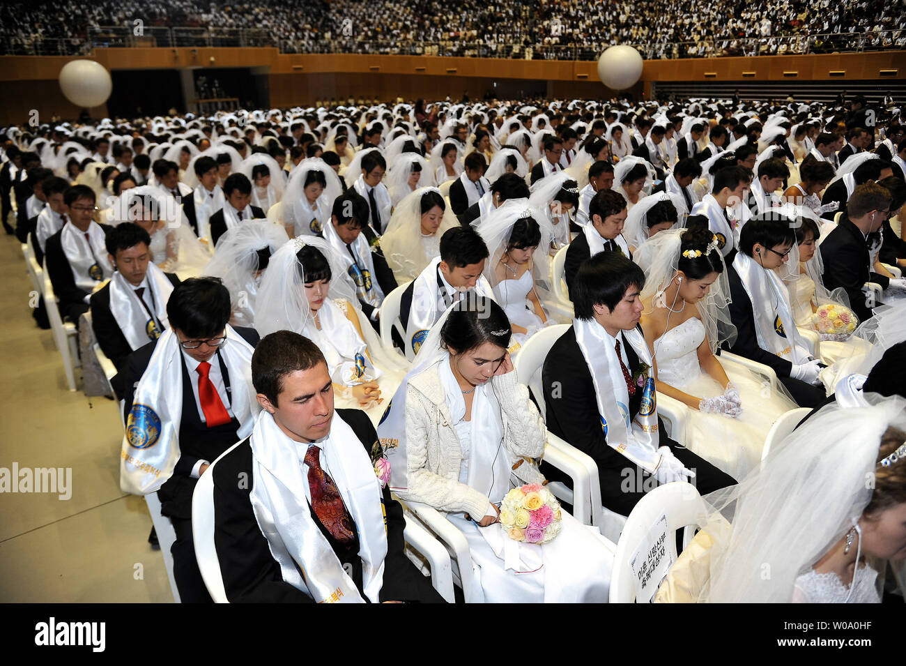 Newly married couples pray during a Blessing Ceremony of the Family Federation for World Peace and Unification at the CheongShim Peace World Center in Gapyeong, South Korea, on February 20, 2016.     Photo by keizo Mori Stock Photo