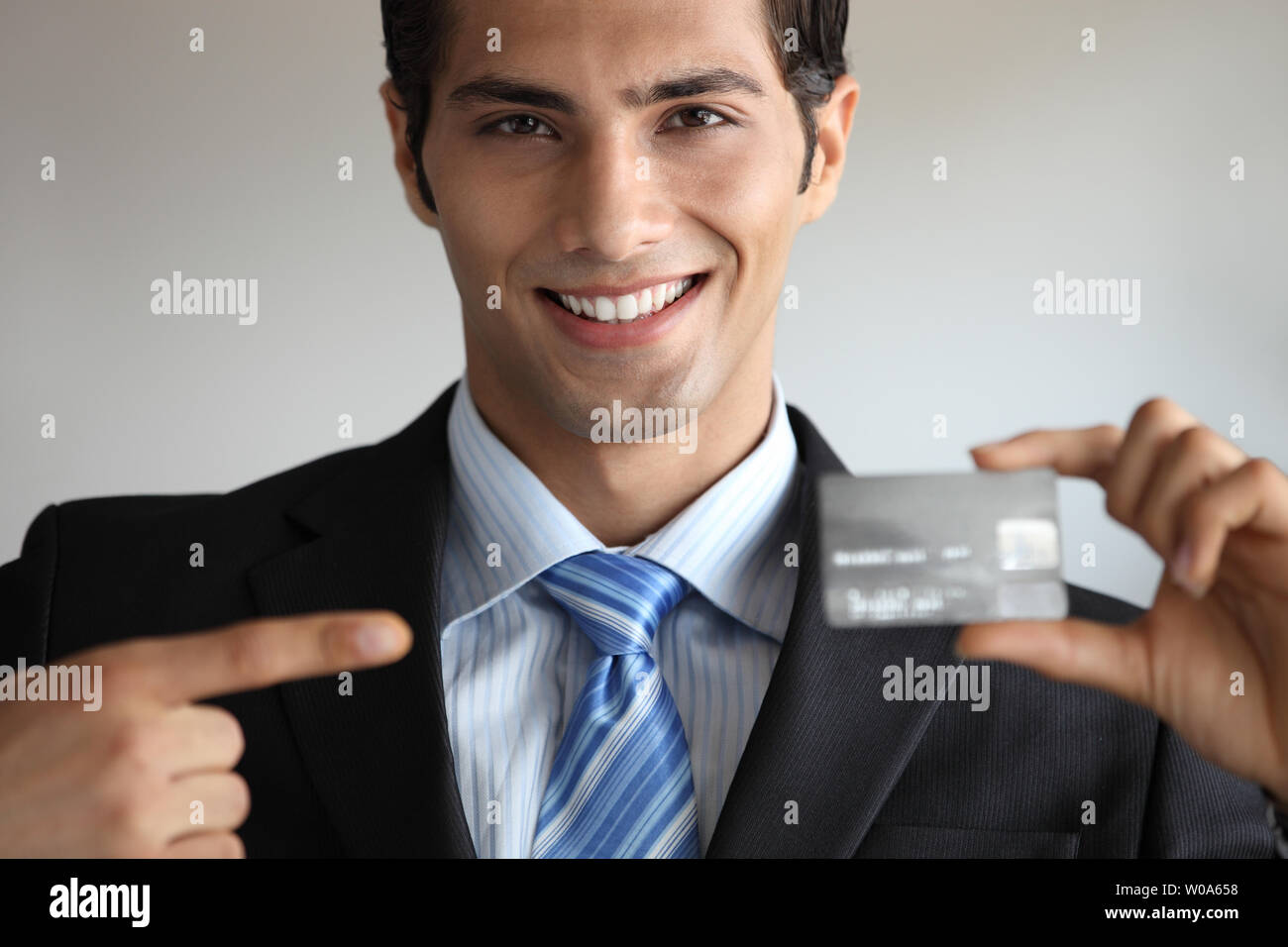 Indian businessman showing a credit card Stock Photo - Alamy