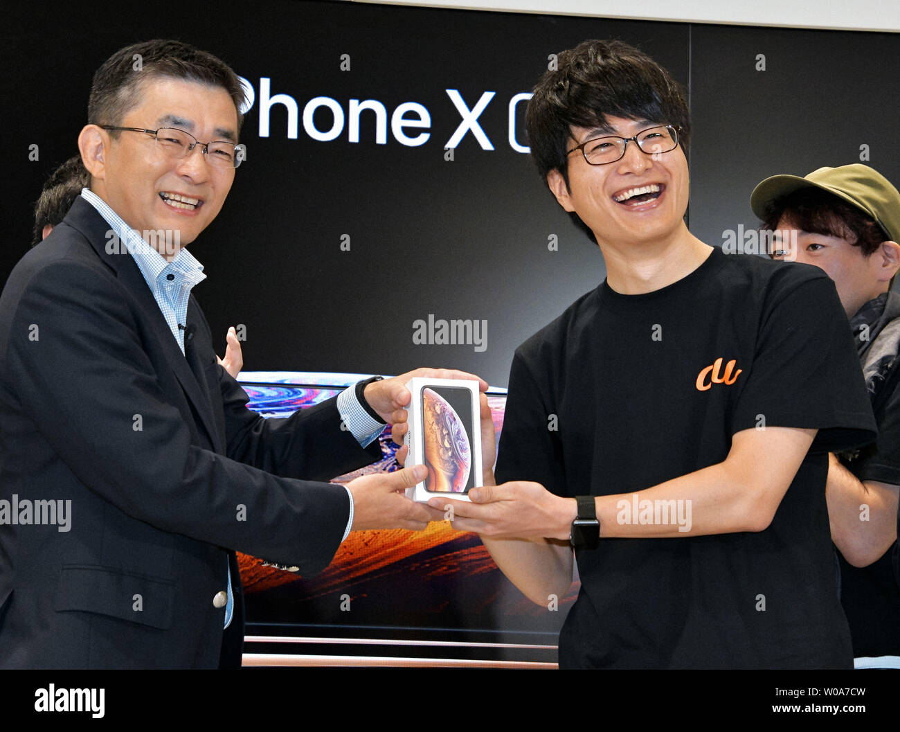 Makoto Takahash(L)i, President of KDDI Corporation and first customer pose for camera during a launch event for Apple New iPhone Xs and Xs Max at the KDDI's au Shinjuku store in Tokyo, Japan, on September 21, 2018.     Photo by Keizo Mori/UPI Stock Photo