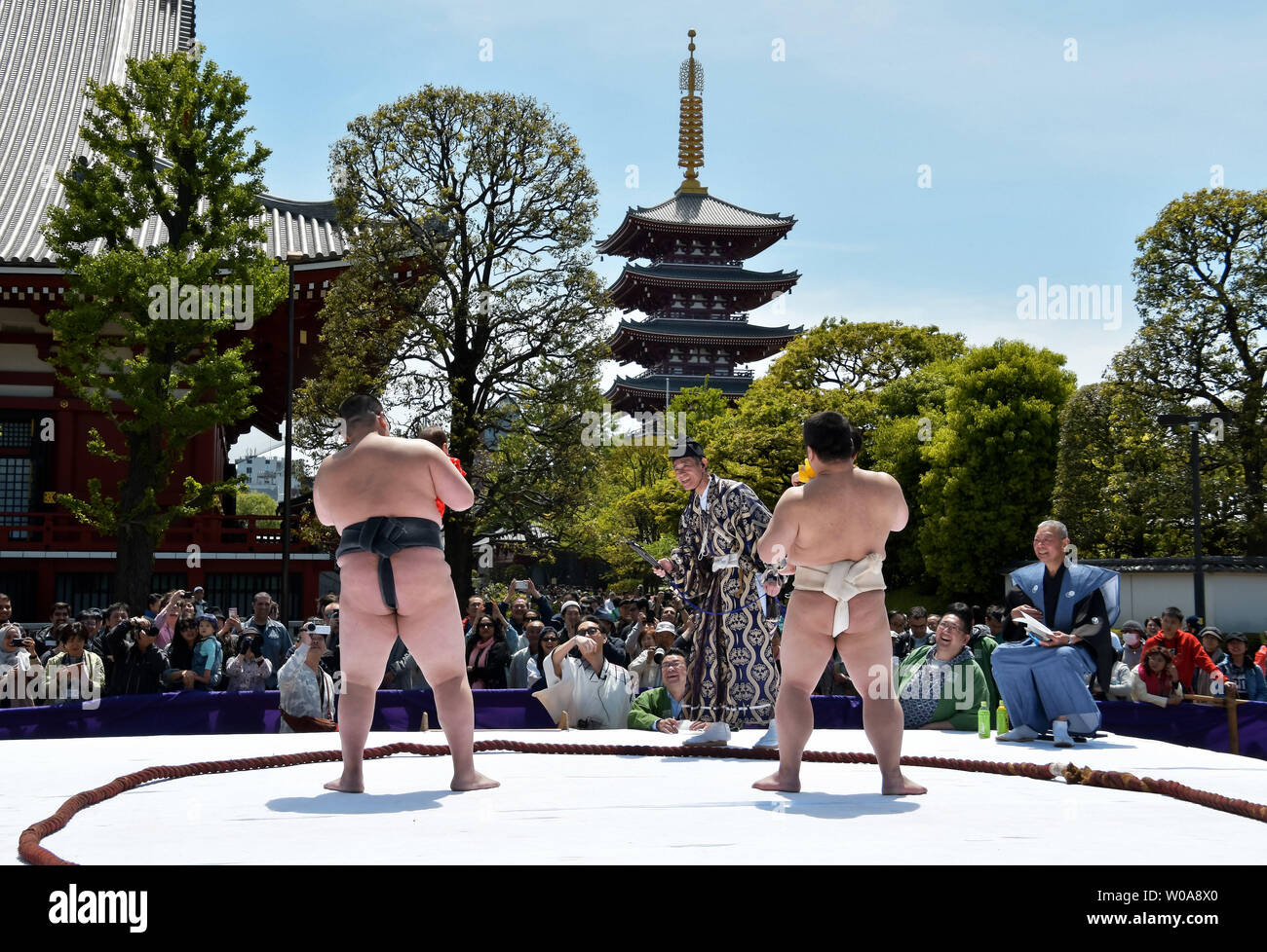 Babies held by an amateur sumo wrestler cry during the 