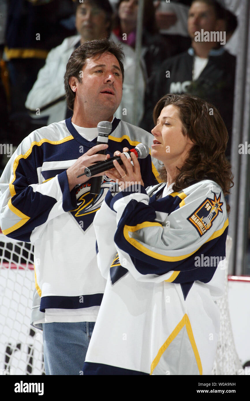 Vince Gill (left) and Amy Grant sing the National Anthem before game