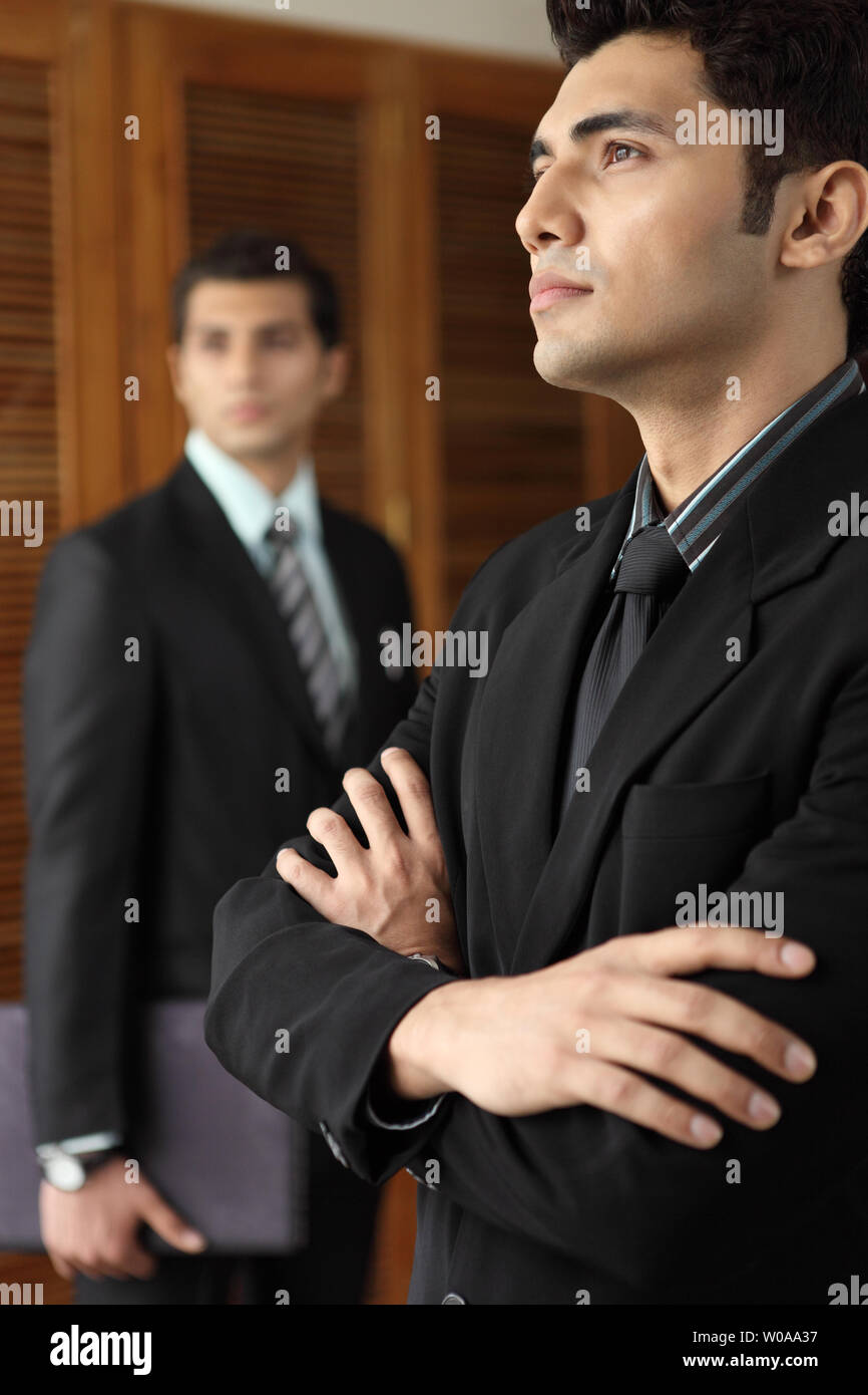 Indian businessman standing with his arms crossed Stock Photo - Alamy
