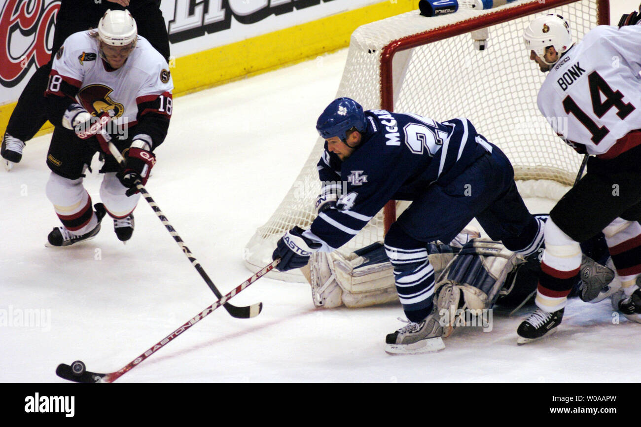 Toronto Maple Leafs' Bryan McCabe clears the puck away from the Leafs net as Ottawa Senators' Marian Hossa(no. 18) charges in during second period action in Game 7 of their series in the first round of the NHL playoffs at the Air Canada Center in Toronto, Canada on Apr. 20, 2004. The Leafs defeated the Senators 4-1 to advance to the next round. (UPI Photo/Christine Chew) Stock Photo