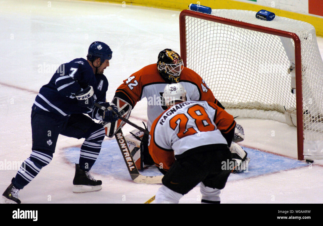 Toronto Maple Leafs' Gary Roberts' shot beats Philadelphia Flyers' Marcus Ragnarsson and goalie Robert Esche but narrowly misses the net in second period action during Game 6 of their series in the second round of the NHL playoffs at the Air Canada Center in Toronto, Canada on May 4, 2004. The Flyers went on to defeat the Leafs 3-2 in sudden-death overtime with a goal by Jeremy Roenick and won the series 4-2. (UPI Photo/Christine Chew) Stock Photo