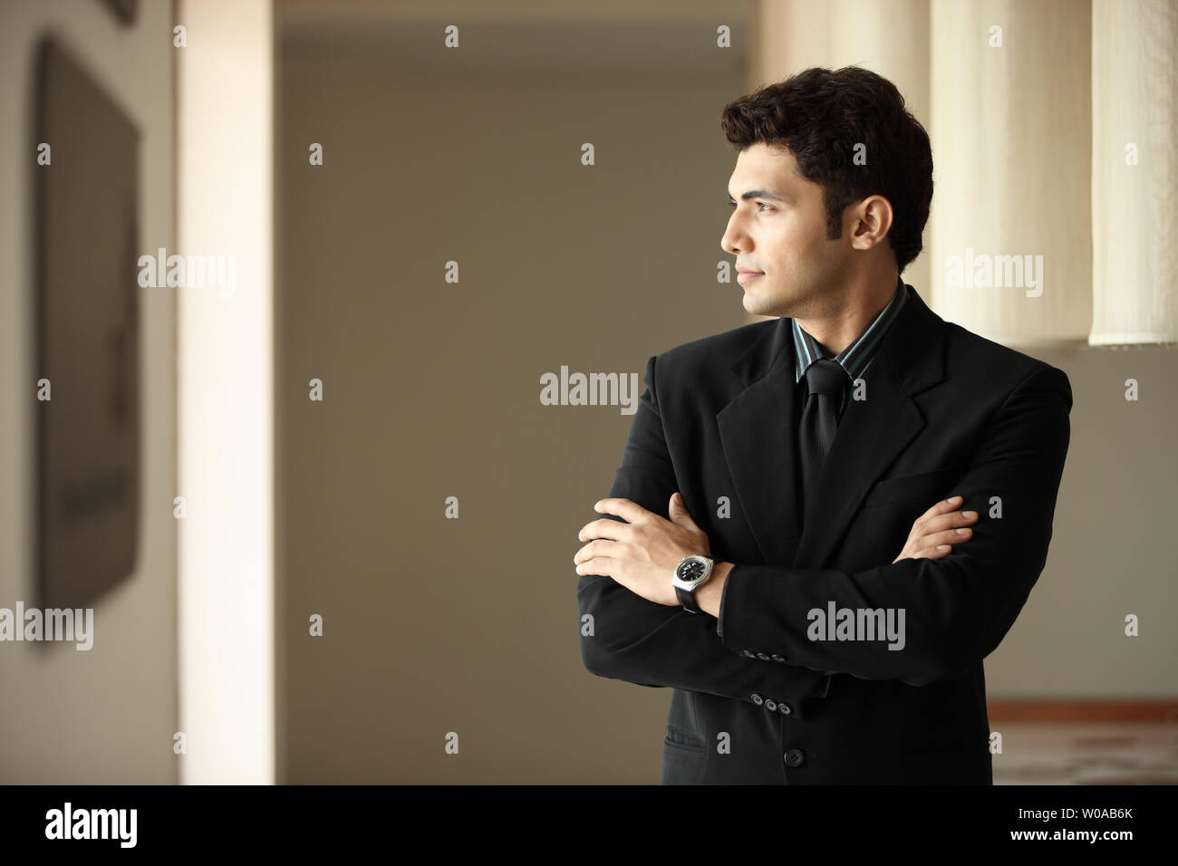 Indian businessman standing with his arms crossed Stock Photo - Alamy