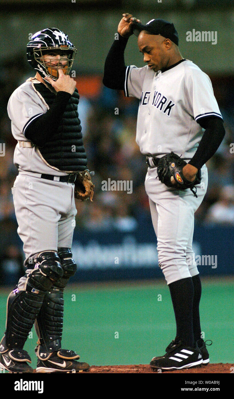 New York Yankees starting pitcher Orlando Hernandez and catcher John  Flaherty confer on the mound after getting into trouble and loading the  bases on walks in third inning action against the Toronto