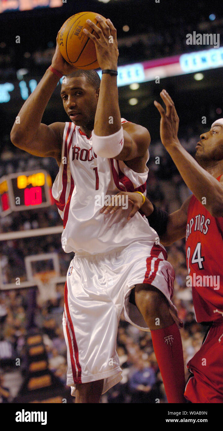 Houston Rockets' Tracy McGrady grabs a rebound away from Toronto Raptors' Morris Peterson during second quarter action in the Raptors' home opener at the Air Canada Center November 3, 2004 in Toronto, Canada.  (UPI Photo/Christine Chew) Stock Photo