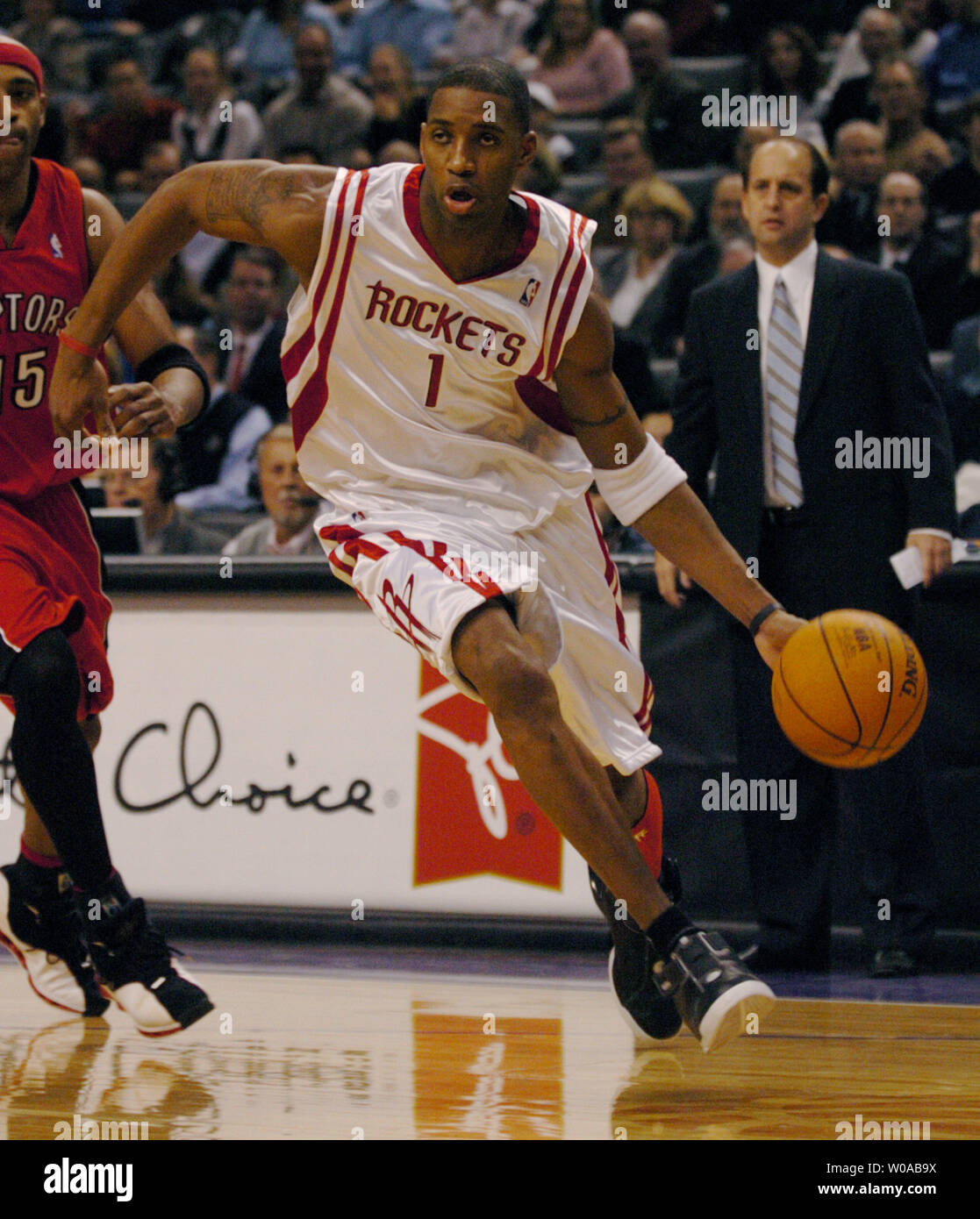 Houston Rockets' Tracy McGrady drives the ball past Toronto Raptors' Vince Carter during first quarter action in the Raptors' home opener at the Air Canada Center November 3, 2004 in Toronto, Canada. The Raptors went on to defeat the Rockets 95-88. (UPI Photo/Christine Chew) Stock Photo