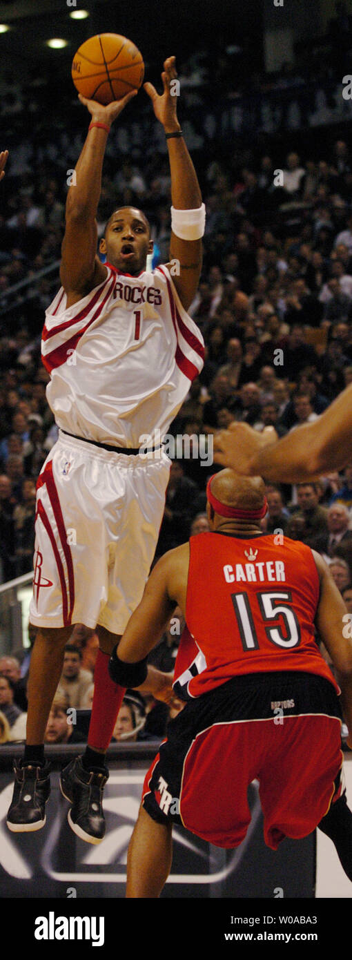 Houston Rockets' Tracy McGrady makes a jump shot over Toronto Raptors' Vince Carter during second quarter action in the Raptors' home opener at the Air Canada Center November 3, 2004 in Toronto, Canada. The Raptors went on to defeat the Rockets 95-88. (UPI Photo/Christine Chew) Stock Photo