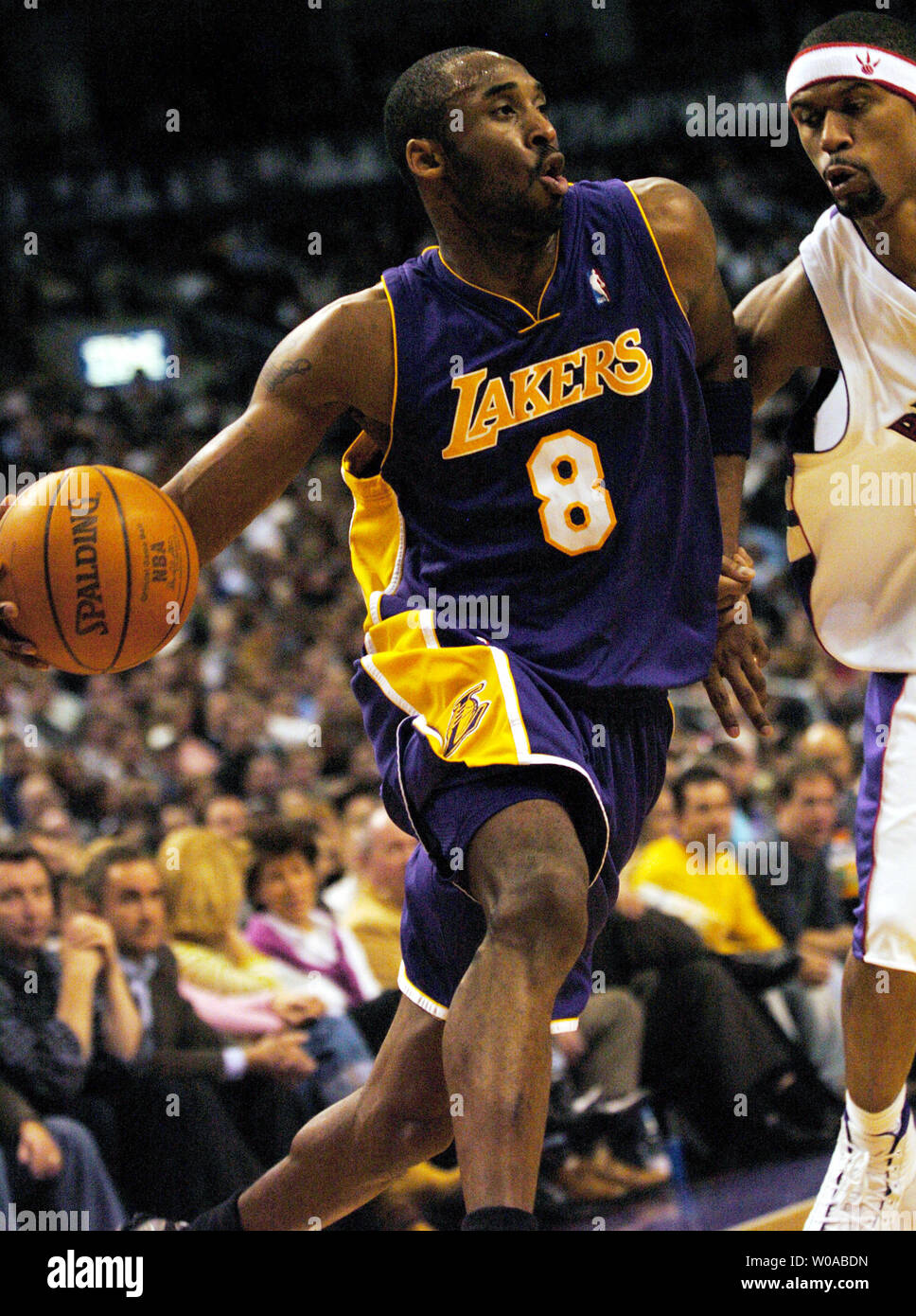 Los Angeles Lakers' Kobe Bryant drives the ball into the paint by Toronto Raptors' Jalen Rose during third quarter action at the Air Canada Center February 27, 2005 in Toronto, Canada. Bryant led all scorers with 31 points but the Raptors went on to defeat the Lakers 108-102. (UPI Photo/Christine Chew) Stock Photo