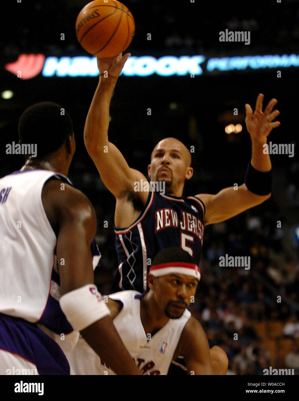 New Jersey Nets' Jason Kidd jumps above Toronto Raptors' Jalen Rose and