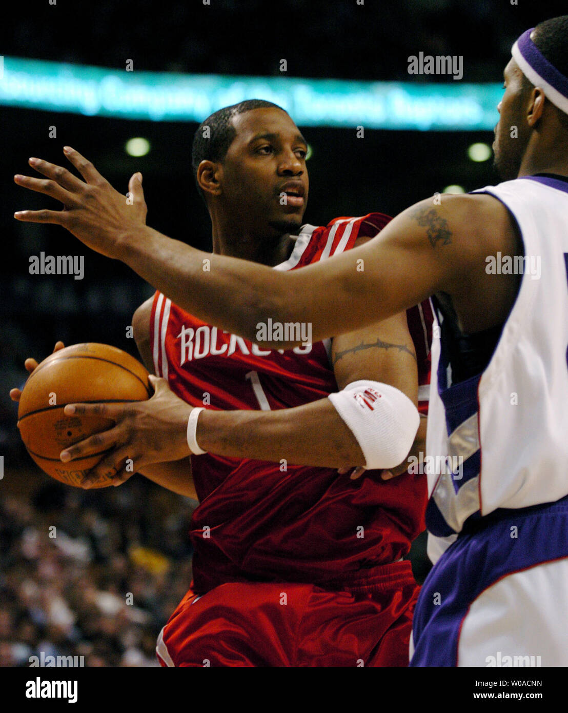 Houston Rockets' Tracy McGrady looks for a teammate to pass to as Toronto Raptors' Morris Peterson guards him during first quarter action at the Air Canada Center on January 6, 2006 in Toronto, Canada. McGrady led all scorers with 37 points on the night but the Raptors defeated the Rockets 112-92. (UPI Photo/Christine Chew) Stock Photo