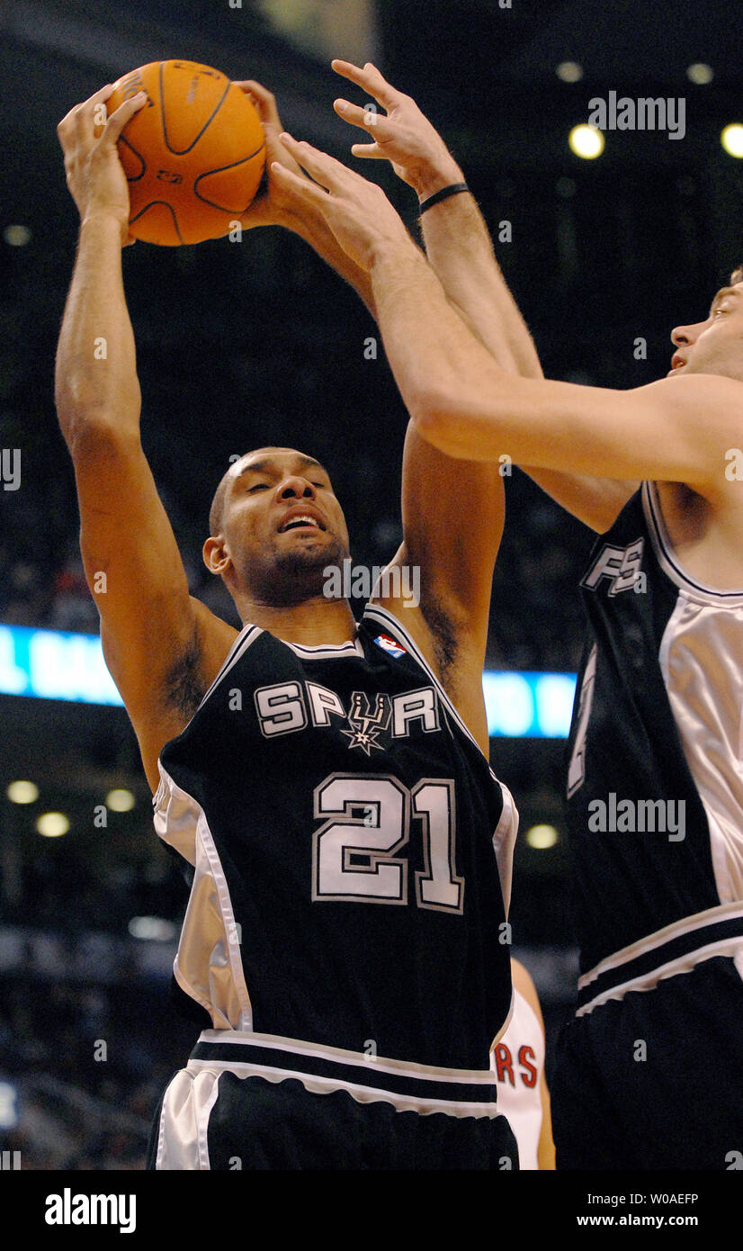San Antonio Spurs' Tim Duncan comes down with the ball as he and teammate  Fabricio Oberto went up for the defensive rebound in first quarter action  against the Toronto Raptors at the