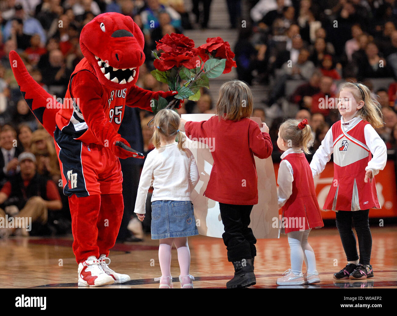 The Raptor, mascot of the Toronto Raptors, receives flowers from young fans during the Valentine's Day game against the New Jersey Nets at the Air Canada Center in Toronto, Canada on February 14, 2007. The Raptors defeated the Nets 120-109. (UPI Photo/Christine Chew) Stock Photo