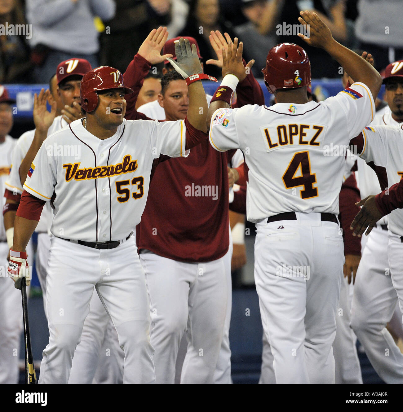 Team Venezuela's Bobby Abreu (no. 53) and teammates clear the dugout to